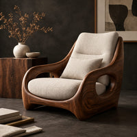 Corner detail of sculpted lounge chair with oval side cutouts and a cushioned seat beside wood, brass and linen samples
