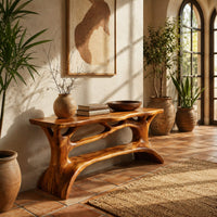 Shoe bench with a slab top, root style supports and an open shelf in a bright entryway with arched windows and plants