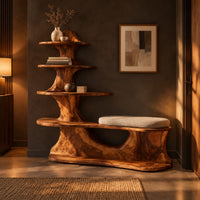 Sculpted wood shoe bench with a cushioned seat and a tower of shelves in a dark entryway at golden hour