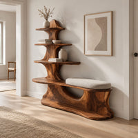 Sculpted wood shoe bench with a cushioned seat and a tower of shelves in a Scandinavian entryway with white walls