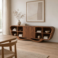 Sculpted sideboard with open cubbies and a flowing wave base in a Scandinavian dining room with white walls