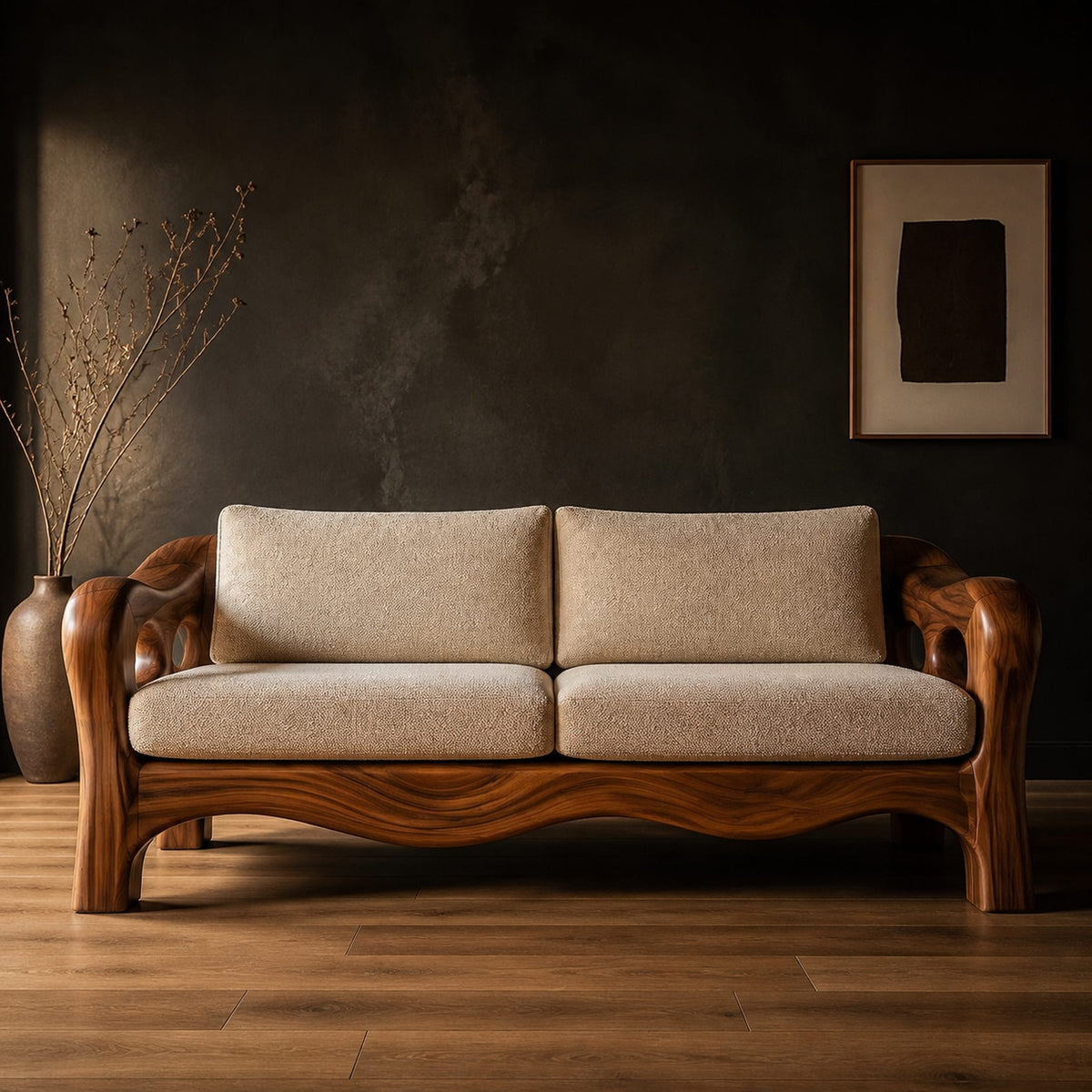 Sculpted wood sofa with open loop arms and a wavy lower rail in a dark studio against a charcoal plaster wall