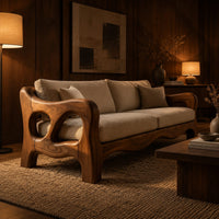 Sculpted wood sofa with open loop arms and a wavy lower rail in an evening living room with walnut wall paneling