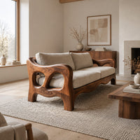 Sculpted wood sofa with open loop arms and a wavy lower rail in a Scandinavian living room with white walls