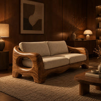 Sofa with thick sculpted arms that have oval openings and a wavy base edge in an evening living room with walnut wall paneling