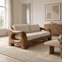 Sofa with thick sculpted arms that have oval openings and a wavy base edge in a Scandinavian living room with white walls