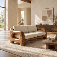 Sofa with thick sculpted arms that have oval openings and a wavy base edge in a bright open plan living room