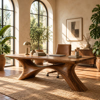 Desk with a plank top on two sweeping legs joined by an arch in a bright home office with arched windows and plants