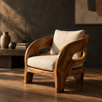 Sculpted wooden lounge chair with oval side cutouts and cream cushions, three-quarter view showing the grain