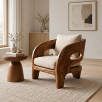 Sculpted wooden lounge chair with oval side cutouts and cream cushions in a Scandinavian living room with white walls