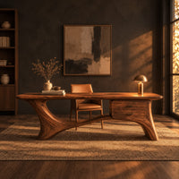 Long desk with sculpted swooping legs and a two drawer unit under the top in a dark home office at golden hour