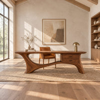 Long desk with sculpted swooping legs and a two drawer unit under the top in a bright open plan home office