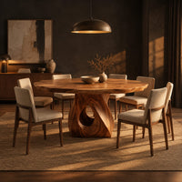 Dining table with a twisted pedestal base and a softly waved edge top in a dark dining room at golden hour