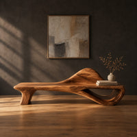 Low bench with a raised wave at one end and an open loop base in a dark studio against a charcoal plaster wall