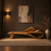 Low bench with a raised wave at one end and an open loop base in a dark entryway at golden hour