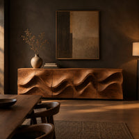 Long low sideboard with sculpted wave relief across the doors in a dark dining room at golden hour
