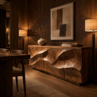Low sideboard with wave relief across four panels and a recessed plinth base in an evening dining room with walnut wall paneling