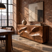 Low sideboard with wave relief across four panels and a recessed plinth base in an industrial loft dining room with exposed brick