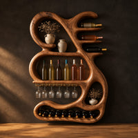 Sculpted wine rack with a looping frame, glass rail and bottle arms in a dark studio against a charcoal plaster wall