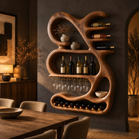 Sculpted wine rack with a looping frame, glass rail and bottle arms in a dark dining room at golden hour
