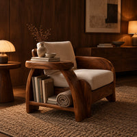 Sculpted wood chair with an oval arm ledge and a cream seat cushion in an evening living room with walnut wall paneling