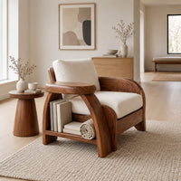 Sculpted wood chair with an oval arm ledge and a cream seat cushion in a Scandinavian living room with white walls