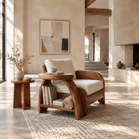 Sculpted wood chair with an oval arm ledge and a cream seat cushion in a bright open plan living room