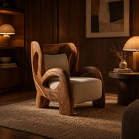 Sculpted lounge chair with looping carved arms, cutout back and cream cushions in an evening living room with walnut wall paneling