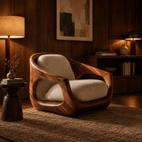 Sculpted wooden lounge chair with open sides and cream seat and back cushions in an evening living room with walnut wall paneling