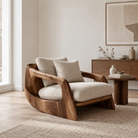 Lounge chair with a sculpted wood shell and thick cream cushions in a Scandinavian living room with white walls