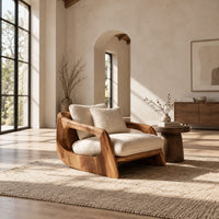 Lounge chair with a sculpted wood shell and thick cream cushions in a bright open plan living room