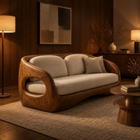 Carved wood shell sofa with oval arm openings and a cushioned seat in an evening living room with walnut wall paneling