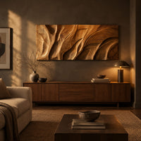 Wooden wall art panel with flowing carved ridges above a low console in an evening living room