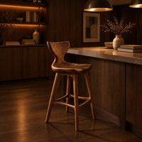 Bar stool with a winged backrest and a dished saddle seat in an evening kitchen with walnut wall paneling