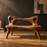 Bench with an open loop backrest and four splayed legs in a dark studio against a charcoal plaster wall
