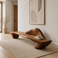 Long wooden bench with a raised wave shaped backrest and curved legs in a Scandinavian entryway with white walls