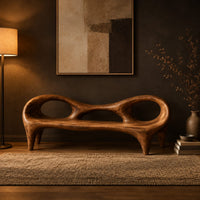 Wooden bench with a low backrest cut with two oval openings on tapered legs in a dark entryway at golden hour
