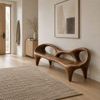 Wooden bench with a low backrest cut with two oval openings on tapered legs in a Scandinavian entryway with white walls