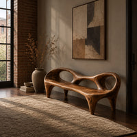 Wooden bench with a low backrest cut with two oval openings on tapered legs in an industrial loft entryway with exposed brick