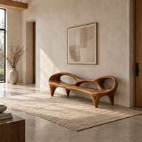 Wooden bench with a low backrest cut with two oval openings on tapered legs in a bright open plan entryway