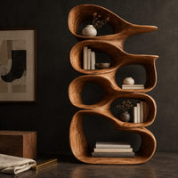 Corner detail of tall bookshelf made of stacked open wooden cells with a pointed top beside wood, brass and linen samples