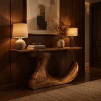 Console table on an off center pedestal with curled foot in an evening entryway with walnut wall paneling