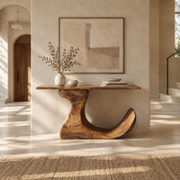 Console table on an off center pedestal with curled foot in a bright open plan entryway