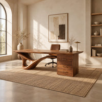 Sculptural desk with a looping wave leg and a three drawer pedestal in a bright open plan home office