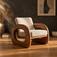 Lounge chair with thick open loop arms and sled base in a dark studio against a charcoal plaster wall