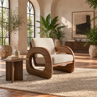 Lounge chair with thick open loop arms and sled base in a bright living room with arched windows and plants