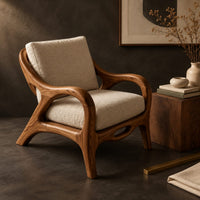 Corner detail of lounge chair with sweeping arms and an oval cutout seat rail beside wood, brass and linen samples