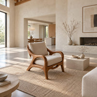 Lounge chair with sweeping arms and an oval cutout seat rail in a bright open plan living room
