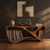Record console with a twisting looped form and open bays at both ends in a dark studio against a charcoal plaster wall