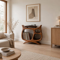 Sculptural record player stand with a large open bay, oval openings and splayed feet in a Scandinavian living room with white walls